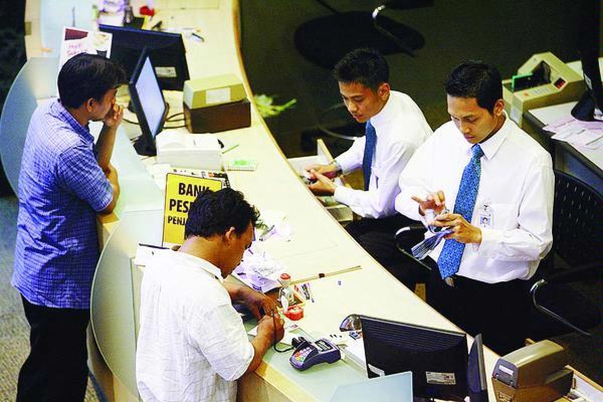 Nasabah bertransaksi di Bank Permata Jakarta, Jumat (10/10). Keputusan Bank Indonesia menaikkan suku bunga acuan 25 basis poin menjadi 9,5 persen diperkirakan berpengaruh pada pertumbuhan kredit perbankan.  