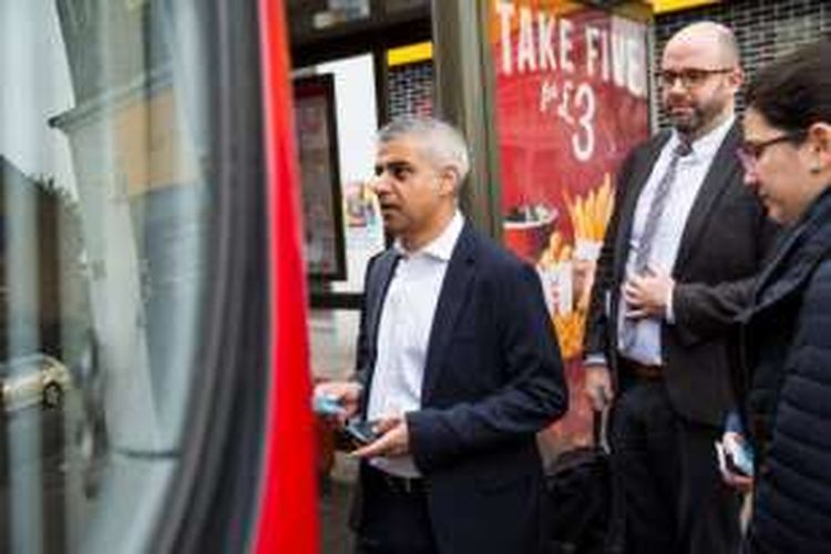 Wali kota London, Sadiq Khan siap naik ke dalam bus di hari pertamanya bekerja di balai kota, Senin (9/5/2016).