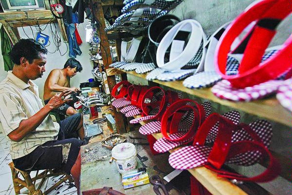 Perajin sepatu skala kecil di kawasan Sumur Batu, Jakarta, merampungkan produksi sepatu wanita untuk pangsa pasar lokal, Sabtu (15/11). Bahan sepatu yang sebagian besar masih diimpor dari China mengalami kenaikan harga 20 persen karena depresiasi nilai tukar rupiah. Akibatnya, omzet para perajin sepatu turun hingga 25 persen.  