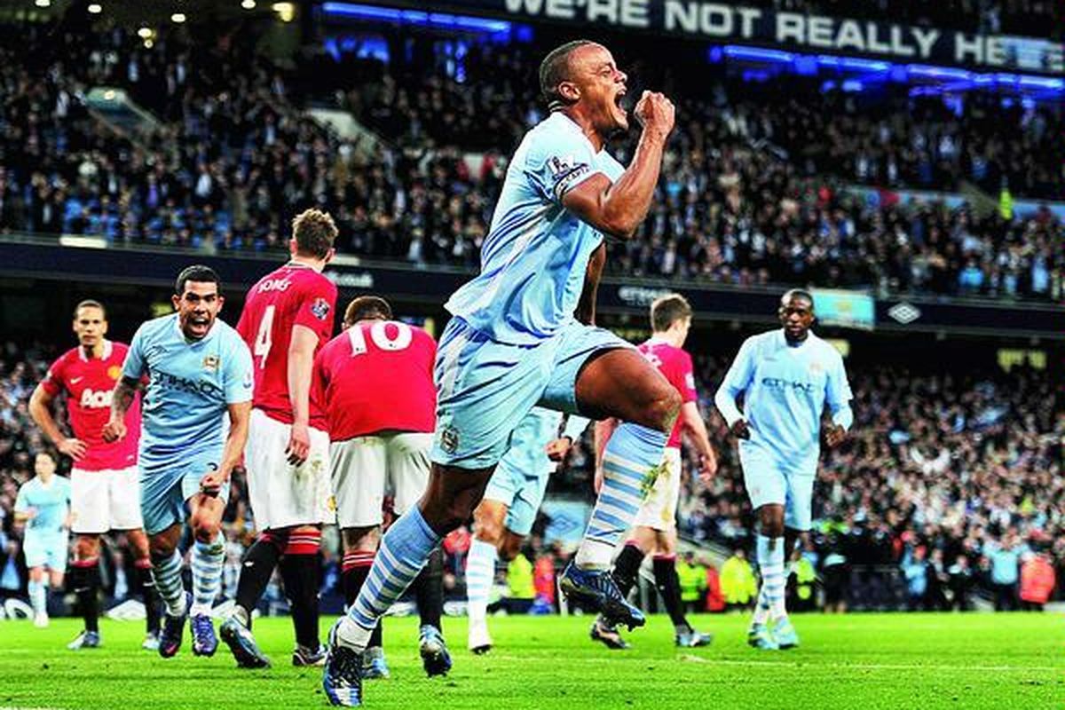 Vincent Kompany, pemain Manchester City, berlari sambil mengepalkan tangan diikuti Carlos Tevez seusai mencetak satu-satunya gol pada pertandingan melawan Manchester United (MU) di Stadion Etihad, Manchester, Senin (30/4). Pada pertandingan derbi ini,  City menang 1-0 atas MU. Kemenangan ini membawa City berada di posisi puncak klasemen sementara Liga Inggris.