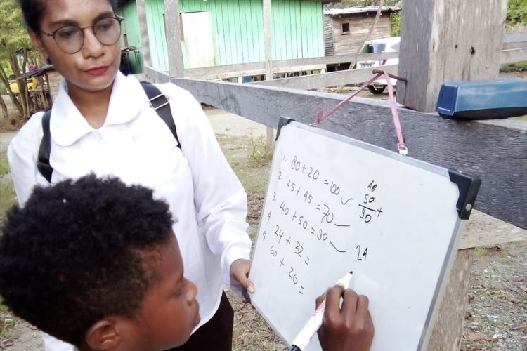 Salah satu Polwan Polres Jayapura terlihat mengajari seorang anak menulis angka di papan tulis dalam program Gabus yang berlangsung di BTN Ceria Sentani, Kabupaten Jayapura, Papua, Senin (27/5/2024).