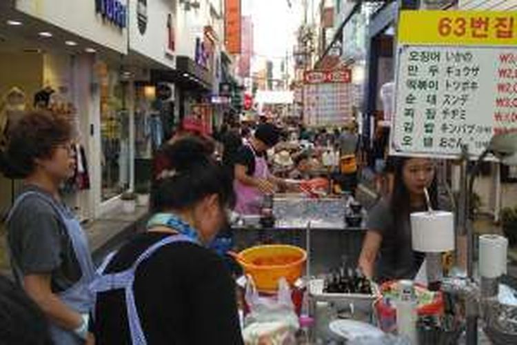 Selain menjual suvenir, Gukje Market di Busan, Korea Selatan juga menjajakan aneka makanan khas Korea. Pembeli pun tak segan menyantap makanan sambil berdiri.