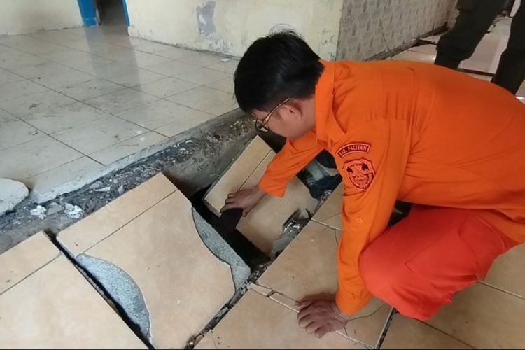 Petugas BPBD Pacitan melihat lantai rumah warga yang rusak, akibat tanah gerak di Desa Karanganyar Kecamatan Kebonagung Kabupaten Pacitan Jawa Timur, Rabu (11/12/2024).