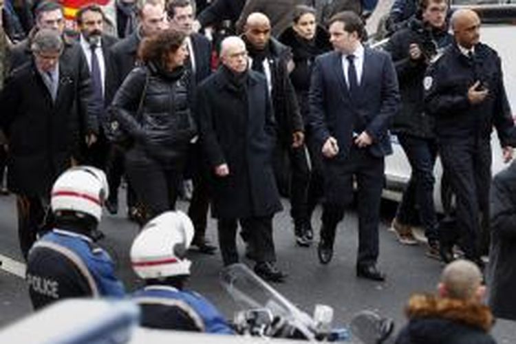 Menteri Dalam Negeri Perancis Bernard Cazeneuve (ketiga dari kiri) meninjau lokasi penembakan polisi di sebelah selatan Paris, Kamis (8/1/2014), yang mengakibatkan dua orang terluka.