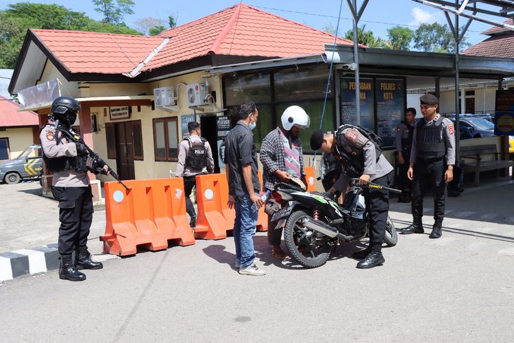 Personel bersenjata lengkap saat memeriksa tamu di pintu penjagaan Mapolres Bima Kota, Kamis (8/12/2022).