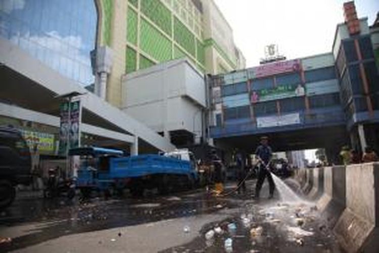 Petugas pemadam kebakaran membersihkan jalan Kebon Melati di kawasan Pasar Tanah Abang, Jakarta Pusat, Minggu (11/8/2013). Ratusan petugas dari berbagai kesatuan dinas menertibkan lapak-lapak pedagang kaki lima dan membersihkan kawasan tersebut.