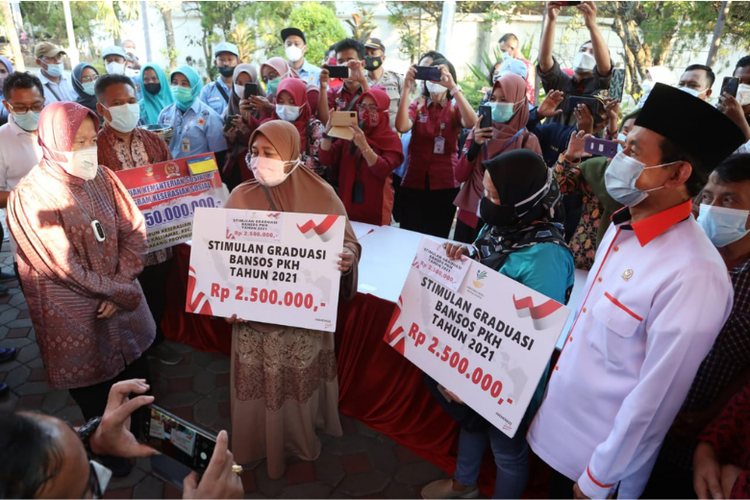 Mensos Tri Rismaharini dan Anggota Komisi VIIl Bukhori Yusuf saat memberikan bantuan kepada masyarakat.