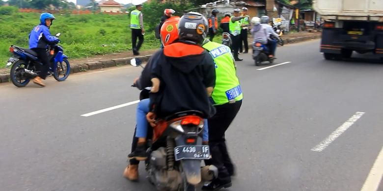 Petugas Polsek Weru, Kabupaten Cirebon, Jawa Barat, berusaha memberhentikan pengendara sepeda motor yang berusaha menghindari razia di Jalur Utama Pantura, Rabu siang (3/2/2016). Petugas langsung memberhentikan, mengambil kunci motor, dan melakukan pemeriksaan. 
