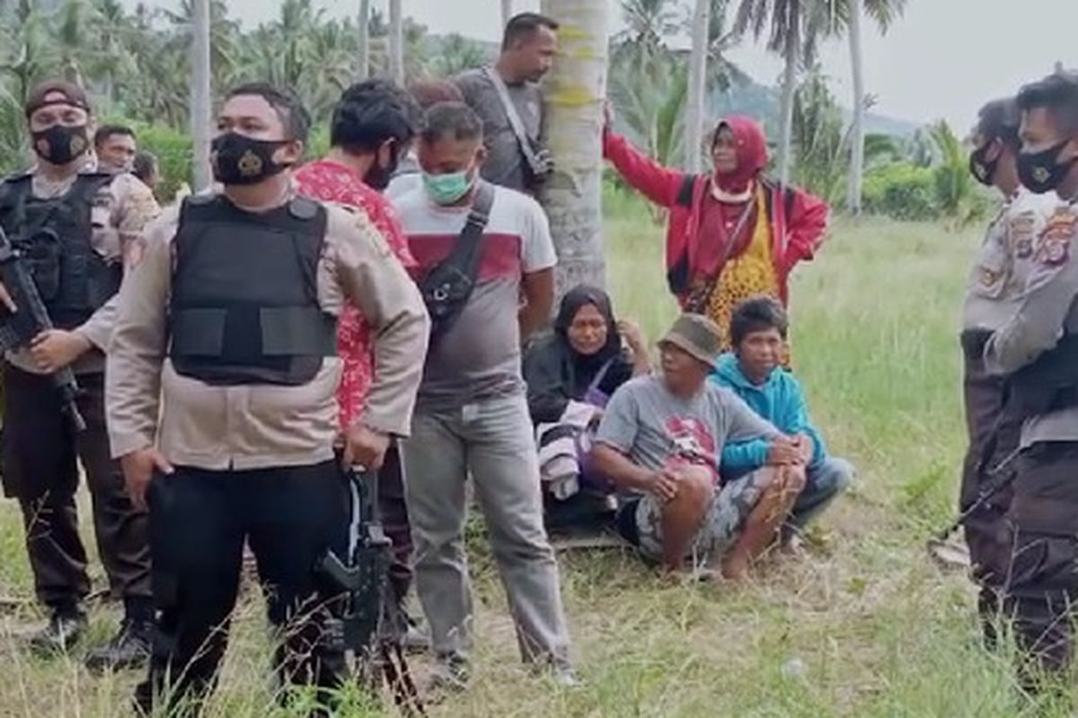 Family of Bojes sitting under a tree as the body of Bojes was taken to an ambulance on Tuesday, November 17.   