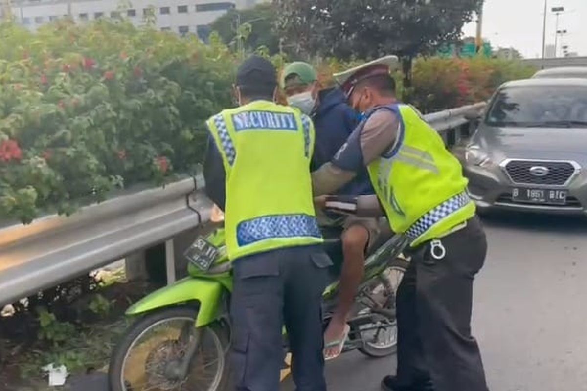 Petugas kepolisian memberhentikan pengendara sepeda motor yang melintas di tol dalam kota kawasan Semanggi, Jakarta Selatan, Rabu (17/11/2021).