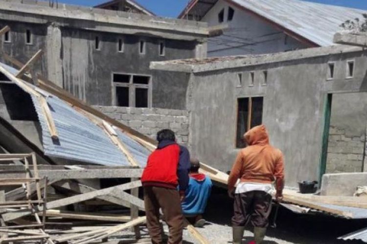 Warga mencoba membersihkan puing-puing bangunan rumahnya yang rusak diterpa angin kencang di Kampung Jeget Ayu, Kecamatan Jagong Jeget, Kabupaten Aceh Tengah, Minggu (15/7/2018).