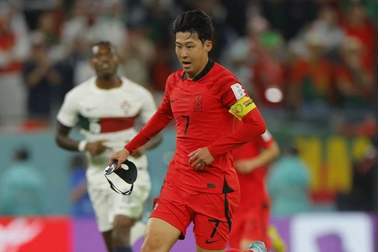 Penyerang Korea Selatan, Son Heung-min, terus berlari meski topeng pelindung wajahnya lepas dalam laga Grup H Piala Dunia 2022 kontra Portugal di Education City Stadium, Ar-Rayyan, Doha, 2 Desember 2022. (Photo by Odd ANDERSEN / AFP)