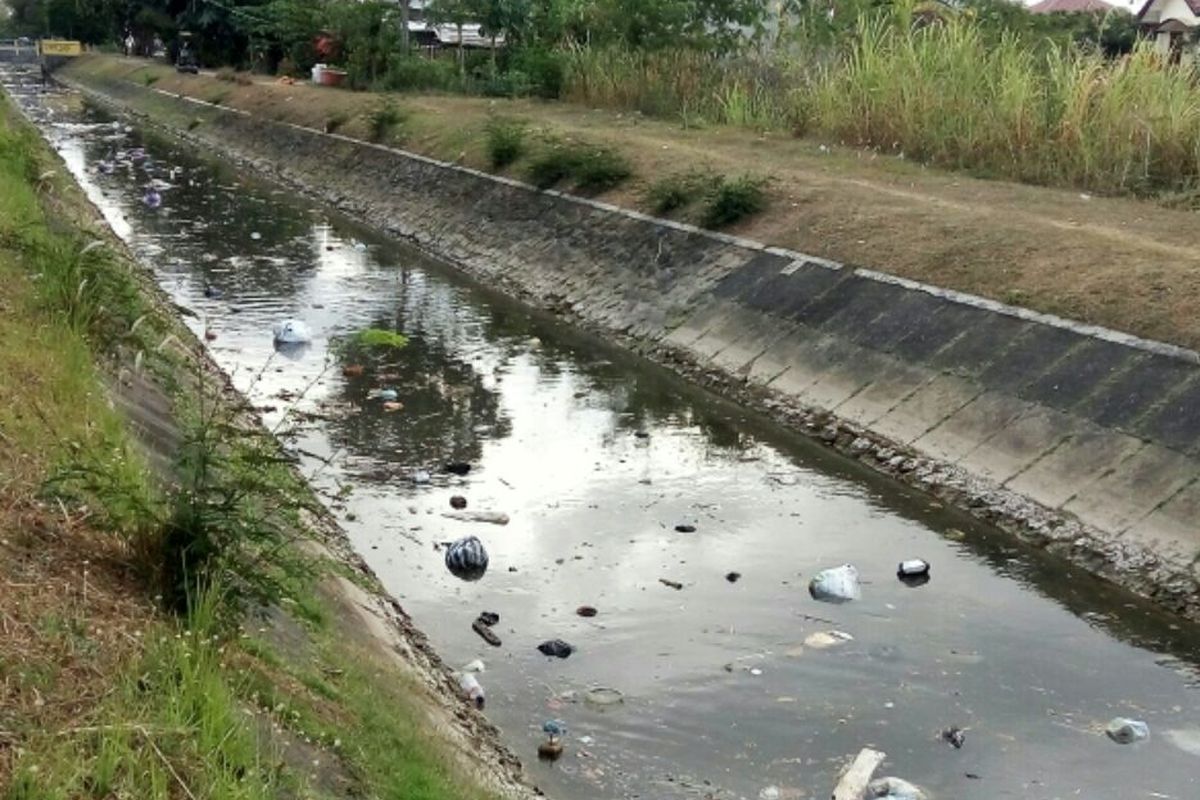 Sampah rumah tangga terlihat mengapung terbawa aliran Selokan Mataram di daerah Kadirojo II Purwomartani, Kalasan, Sleman, 