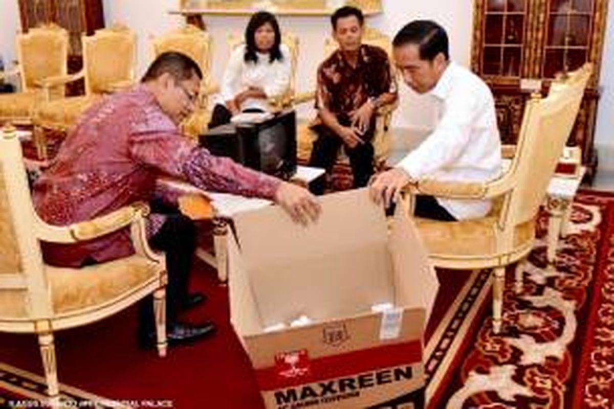 Kusrin menunjukkan TV hasil karyanya yang diberi merk MAXREEN kepada Presiden Joko Widodo di Istana Merdeka, Senin (25/1/2016).