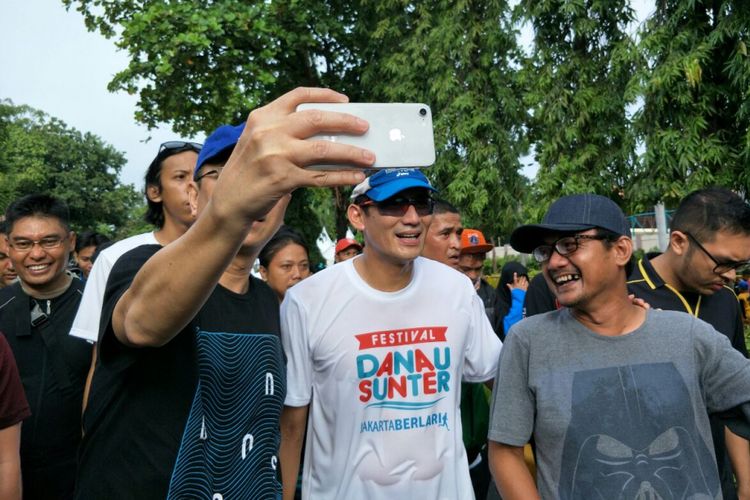 Wakil Gubernur DKI Jakarta Sandiaga Uno berfoto dengan warga usai lari 5 kilometer di sekitar Danau Sunter, Minggu (25/2/2018). 