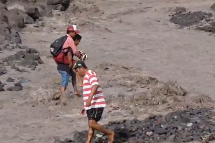 Ilustrasi siswa Sumberlangsep digendong menyebrangi aliran lahar untuk bisa ke sekolah, Kamis (4/12/2025)