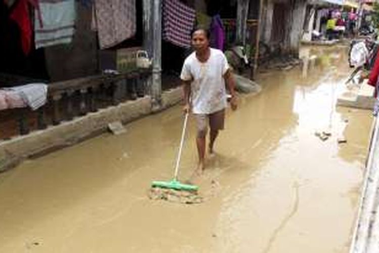 Warga Desa Gebang Udik, Kecamatan Gebang, Kabupaten Cirebon, Jawa Barat, membersihkan lumpur sisa banjir di permukiman warga, Selasa (3/1/2017). Banjir yang menerjang enam desa di Gebang sejak Minggu (1/1) malam mulai surut pada Senin (2/1) pukul 23.00. Setidaknya 1.475 rumah terendam di daerah tersebut akibat hujan deras, rob, serta minimnya saluran pembuangan. 