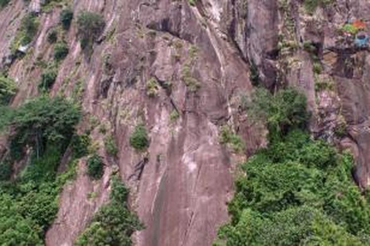 Miftah (tengah) tampak terlihat hanya noktah merah kecil ketika melakukan pemanjatan di Tebing Parang Tower Tiga dengan jalur bernama Bandung Rock, Kamis (26/2/2015).