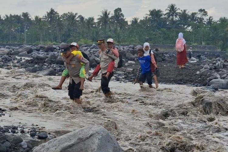 Polisi di Lumajang Seberangkan Siswa Pulang Sekolah Lewati Aliran Lahar Hujan Semeru