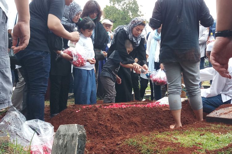 Penyanyi Intan RJ bersama anak keduanya, Abdullah Maulana Utama, saat menaburi air mawar di atas pusara mendiang suaminya, Wahyu Indra Utama, di Tempat Pemakaman Umum (TPU) Duri Kepa, Jakarta Barat, Sabtu (14/3/2020).