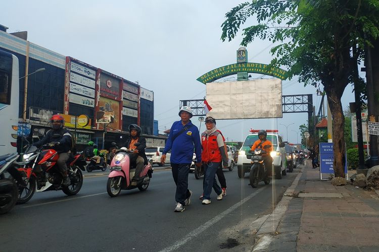 Komaruddin Rachmat (biru), penyintas stroke yang berjalan kaki dari Bandung ke Jakarta berhasil mencapai Kota Bekasi pada Senin (28/10/2019) sore.