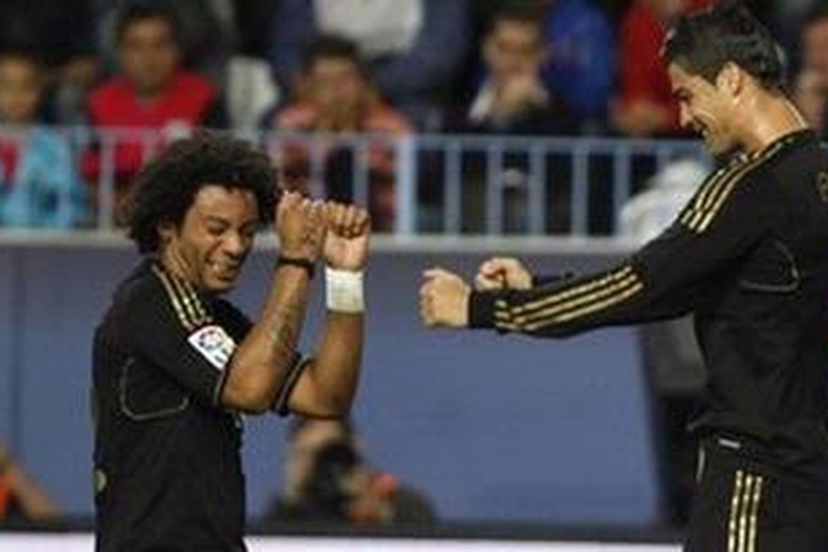 Pemain Real Madrid, Cristiano Ronaldo (kanan) dan Marcelo bergoyang sebagai bentuk selebrasi setelah Cristiano Cristiano mencetak gol ke gawang Malaga dalam laga lanjutan La Ligadi stadion La Rosaleda di Malaga, 22, Oktober 2011.