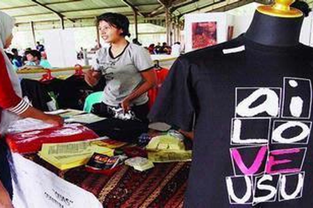 Seorang mahasiswi melayani calon pembeli yang mampir di stannya di pendopo Universitas Sumatera Utara (USU). 