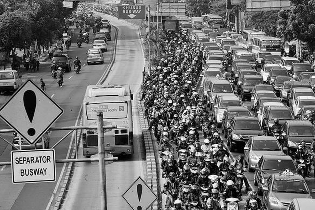 Ratusan pengendara motor melintas di jalur bus transjakarta saat jam sibuk berangkat kerja pagi hari di Jalan Mampang Prapatan, Jakarta, Kamis (6/9). Kondisi ini membuat laju bus transjakarta terganggu.