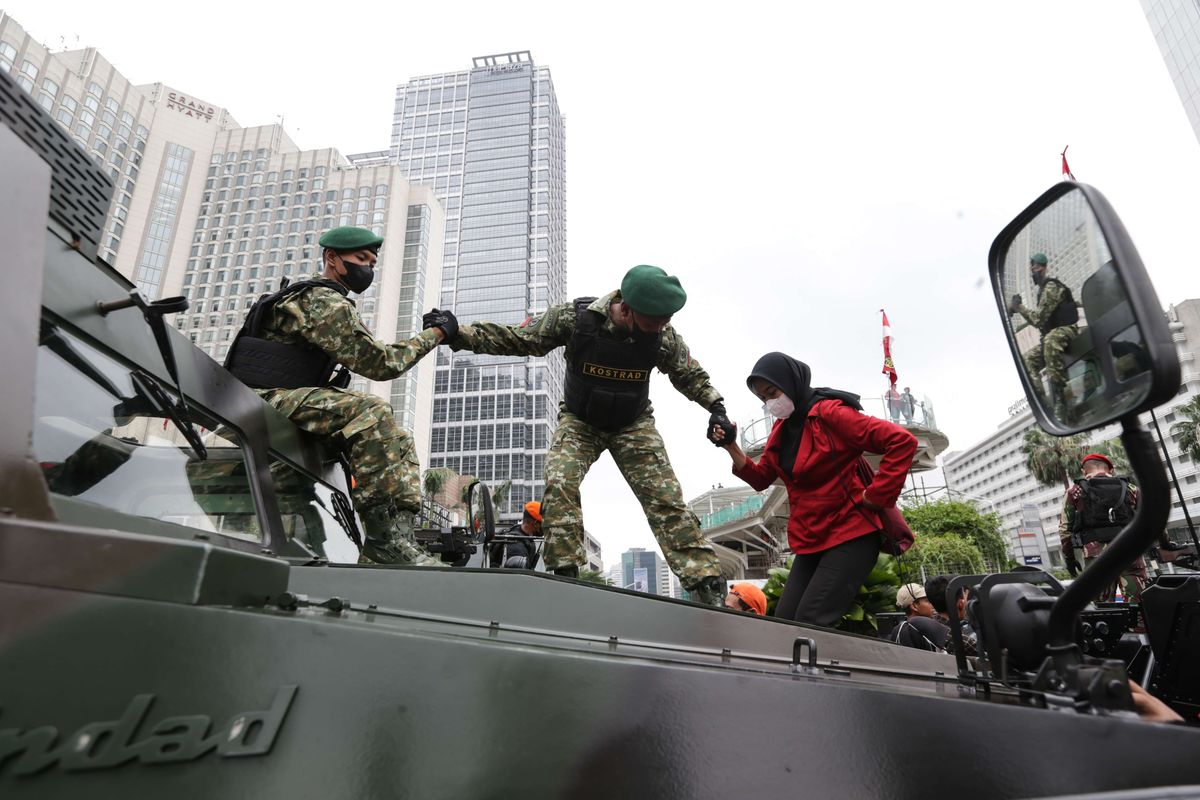 Warga antusias berfoto di atas kendaraan tempur yang terparkir di Bundaran Hotel Indonesia, Jakarta sebagai rangkaian parade perayaan HUT ke-77 TNI, Rabu (5/10/2022).