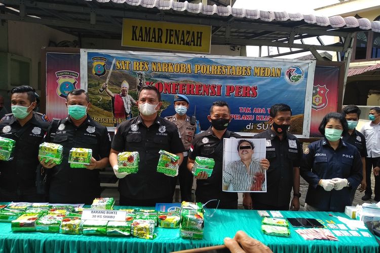 Polisi menunjukkan barang bukti sabu dan wajah AR yang tewas. AR adalah kurir yang akan membawa 30 kg sabu ke Palembang. Tewas ditembak polisi karena melawan dan membahayakan keselamatan petugas.