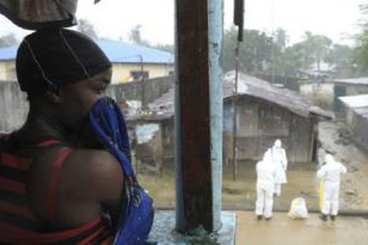 Para petugas melakukan penyemprotan di Liberia untuk mencegah penyebaran.