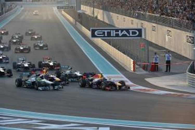 Pebalap Red Bull asal Jerman, Sebastian Vettel memimpin pebalap lain saat memasuki tikungan pertama Sirkuit Yas Marina pada lap pertama GP Abu Dhabi, Minggu (3/11/2013).