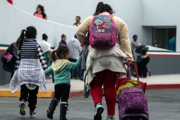 Migran berjalan menuju pelabuhan El Chaparral di Tijuana, Meksiko, di perbatasan dengan AS.