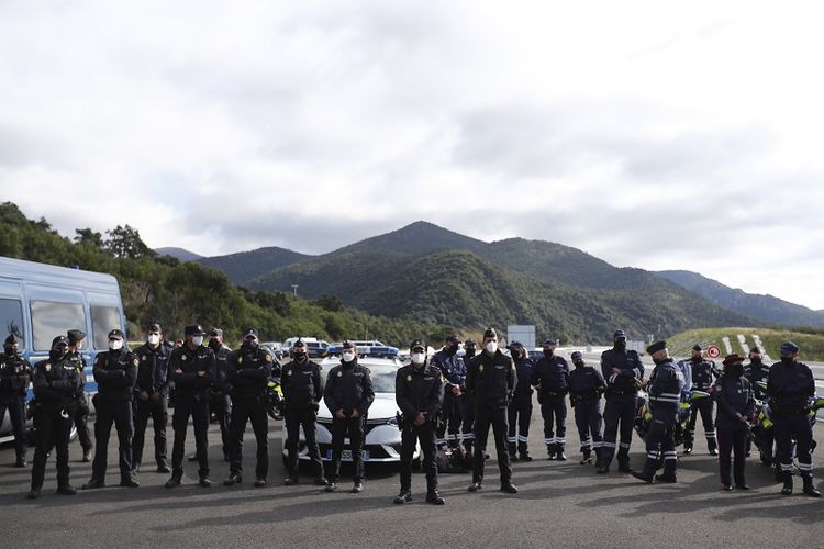 Petugas polisi Perancis berdiri dalam deretan ketika Presiden Emmanuel Macron mengadakan kunjungan untuk memperkuat kontrol perbatasan di persimpangan antara Spanyol dan Perancis, di Le Perthus, Perancis, Kamis, 5 November 2020. 