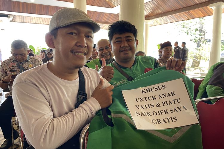 Diki Wahyudi (28), driver ojek online (Ojol) warga Kelurahan Margadadi, Indramayu saat menunjukkan tulisan besar &ldquo;KHUSUS UNTUK ANAK YATIM DAN PIATU NAIK OJEK SAYA GRATIS&rdquo; yang ia tempelkan di bagian punggung jaket ojol miliknya ketika ditemui di Pendopo Indramayu, Jawa Barat, Selasa (7/10/2025)