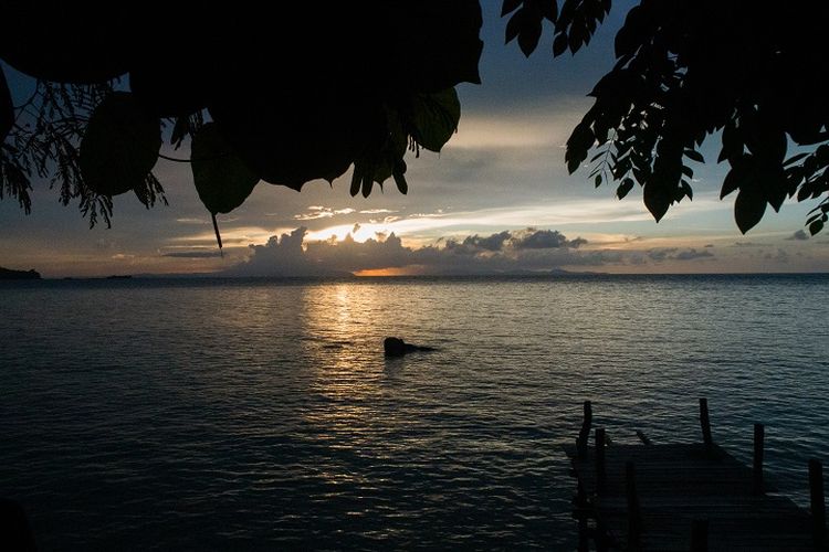 Pemandangan matahari terbenam dan hamparan laut lepas di area dermaga tepi pantai di Kasuari Valley Beach Resort di Kota Sorong, Papua Barat, Senin (25/10/2021).