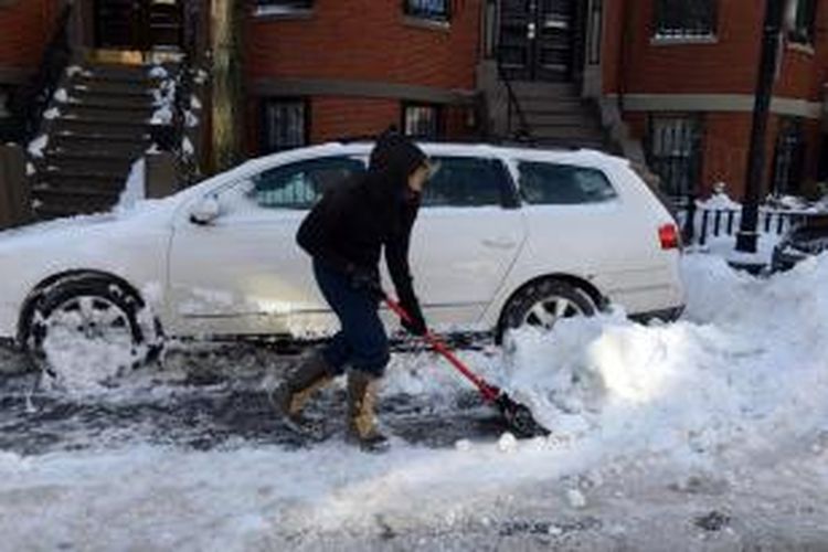 Seorang warga kota Boston, AS mengeruk tumpukan salju yang menjebak mobilnya. Badai salju dan cuaca dingin menghantam sebagian wilayah AS di mana di beberapa wilayah suhu diperkirakan bakal anjlok hingga -15 derajat Celcius.
