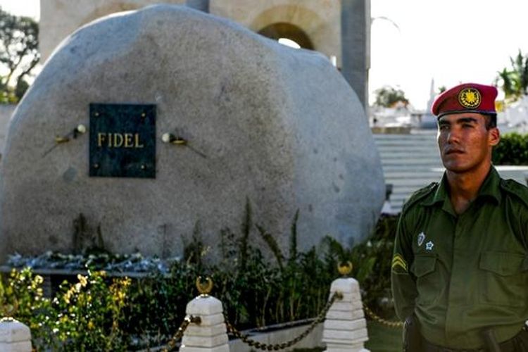 Seorang prajurit Kuba berjaga di depan sebuah batu besar yang menjadi penanda makam pemimpin negeri itu Fidel Castro.