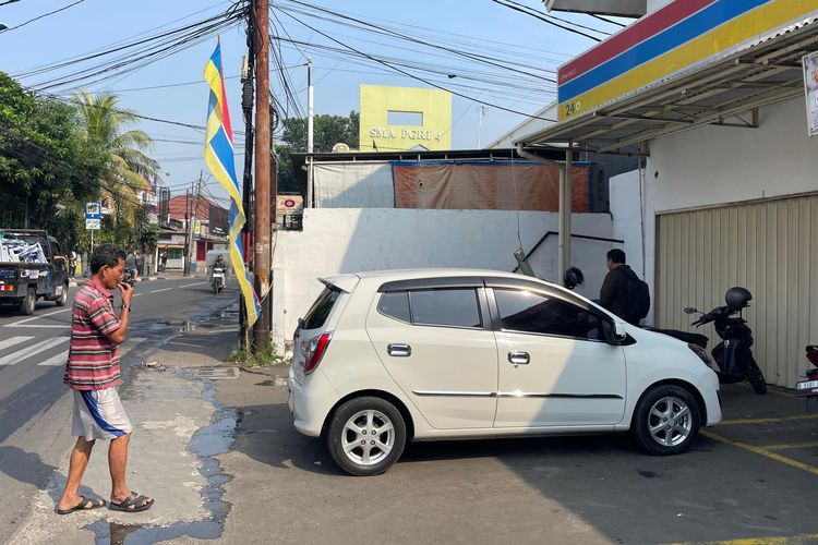 Nana (56) juru parkir minimarket di bilangan Cipayung, Jakarta Timur sedang mengarahkan kendaraan keluar, Sabtu (4/5/2024).