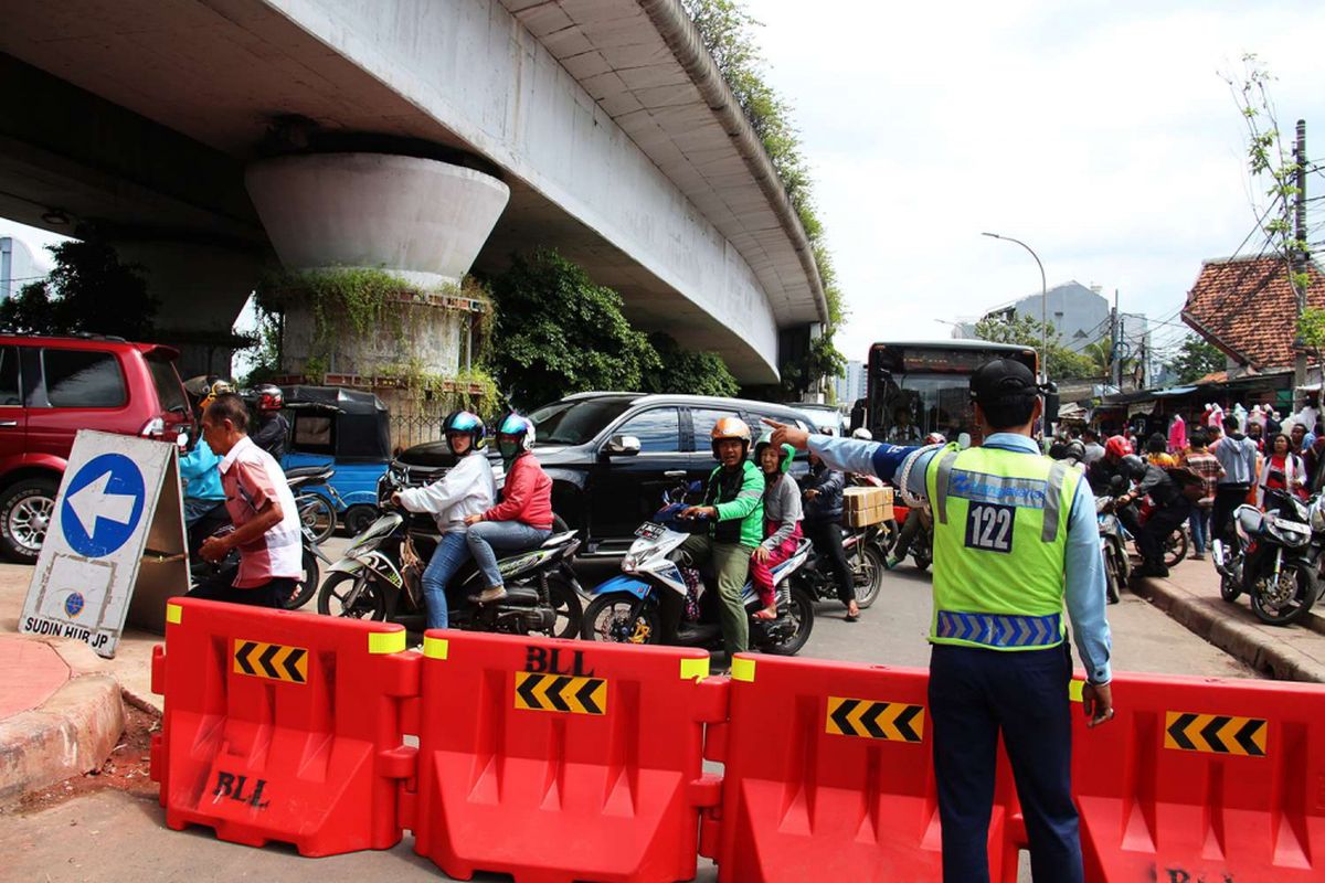 Petugas mengatur jalan yang ditutup di Jalan Jatibaru, Tanah Abang, Jakarta, Jumat (22/12/2017). Sehubung keputusan Gubernur DKI Jakarta Anies Baswedan, ruas jalan di depan stasiun ditutup untuk kendaraan bermotor pada pukul 08.00-18.00 WIB.