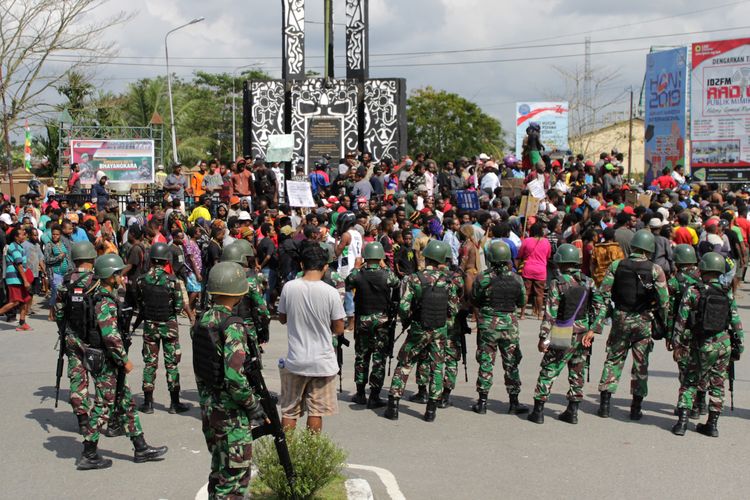 Warga melakukan aksi dengan pengawalan prajurut TNI di Bundaran Timika Indah, Mimika, Papua, Rabu (21/8/2019). Aksi tersebut untuk menyikapi peristiwa yang dialami mahasiswa asal Papua di Surabaya, Malang dan Semarang. ANTARA FOTO/Jeremias Rahadat/wpa/nz.