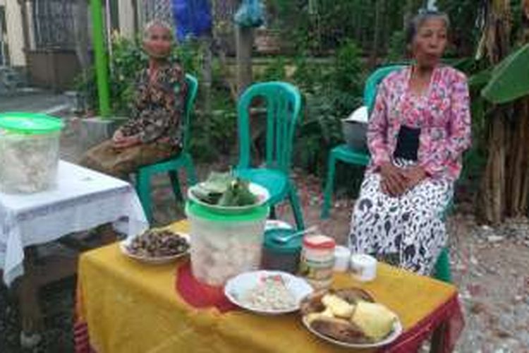 Bik Sari menggunakan kebaya motif bunga berwarna nerah muda di depan meja kayunya. Dia menyiapkan kopi untuk pengunjung di Festival Ngopi Sepuluh Ewu, di Banyuwangi, Jawa Timur, Sabtu (5/11/2016).