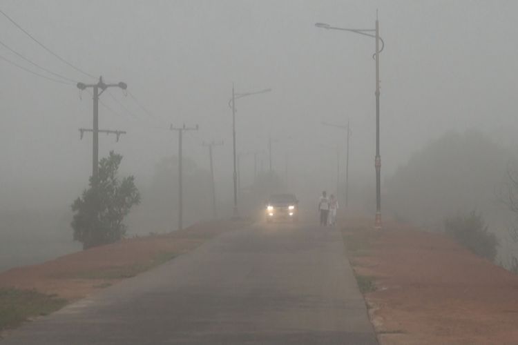 Tebalnya kabut asap yang menyelimuti Ogan Ilir Rabu pagi membuat pengendara haris menyalakan lampu kendaraanya saat melintas