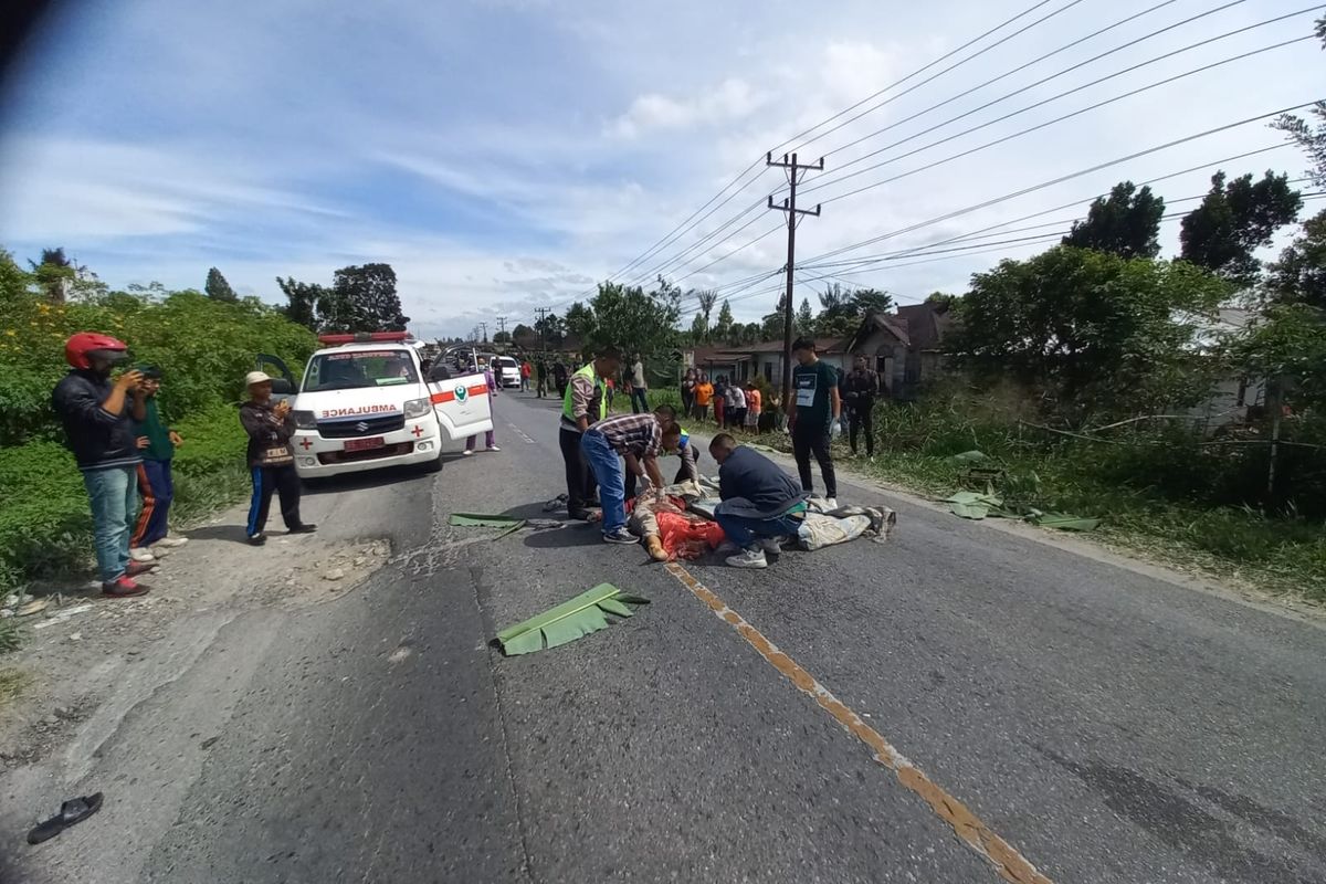 Polisi saat mengevakuasi jenazah wanita yang tewas tertabrak truk karena jalan berlubang di Kecamatan Sipoholan, Taput, Sabtu (13/1/1024)