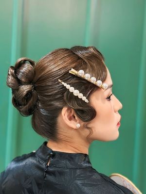 Model dengan tatanan rambut vintage roll bun.