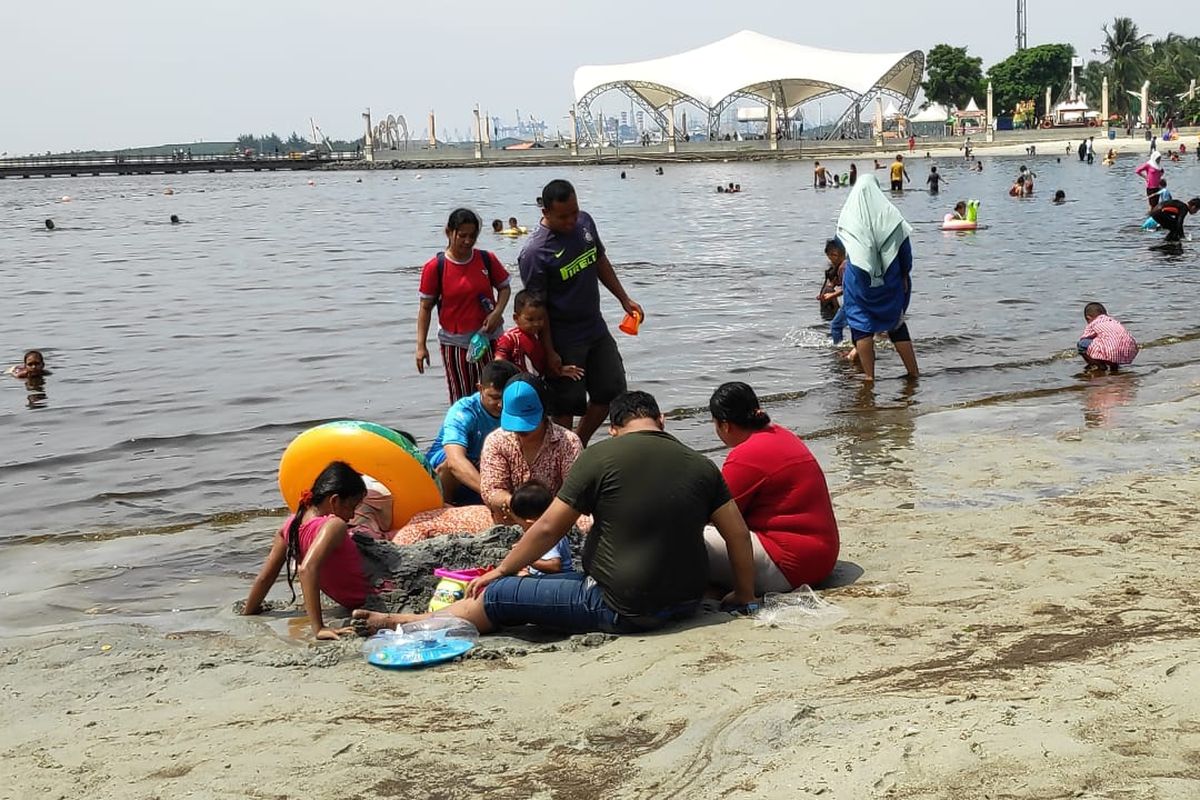  Wisatawan di Pantai Lagoon, Taman Impian Jaya Ancol, Jakarta, Kamis (17/4/2019).