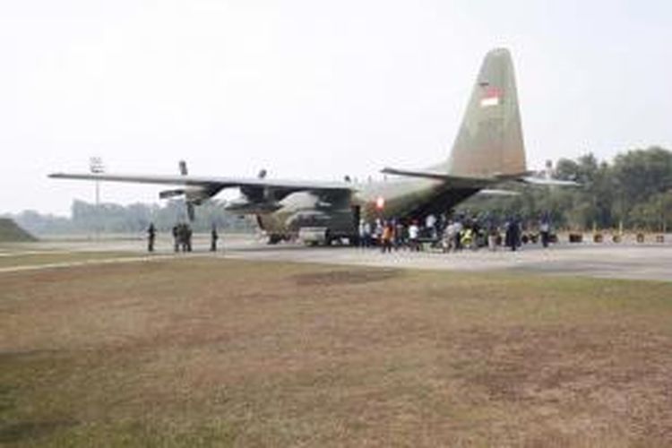 Karung berisi garam dikeluarkan dari pesawat Hercules milik TNI di bandara di Pekanbaru, Riau, untuk persiapan hujan buatan, 22 Juni 2013.