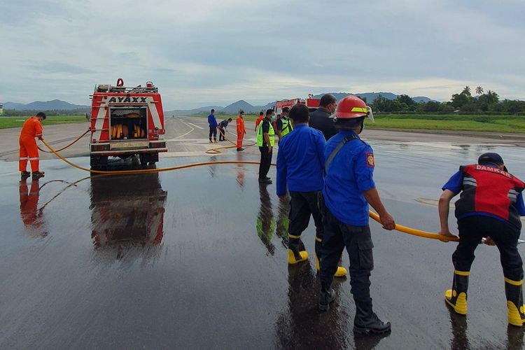 Petugas membersihkan landasan Bandara Sam Ratulangi Manado, Rabu (1/5/2024). 14 mobil pemadam kebakaran dikerahkan membersihkan bandara.