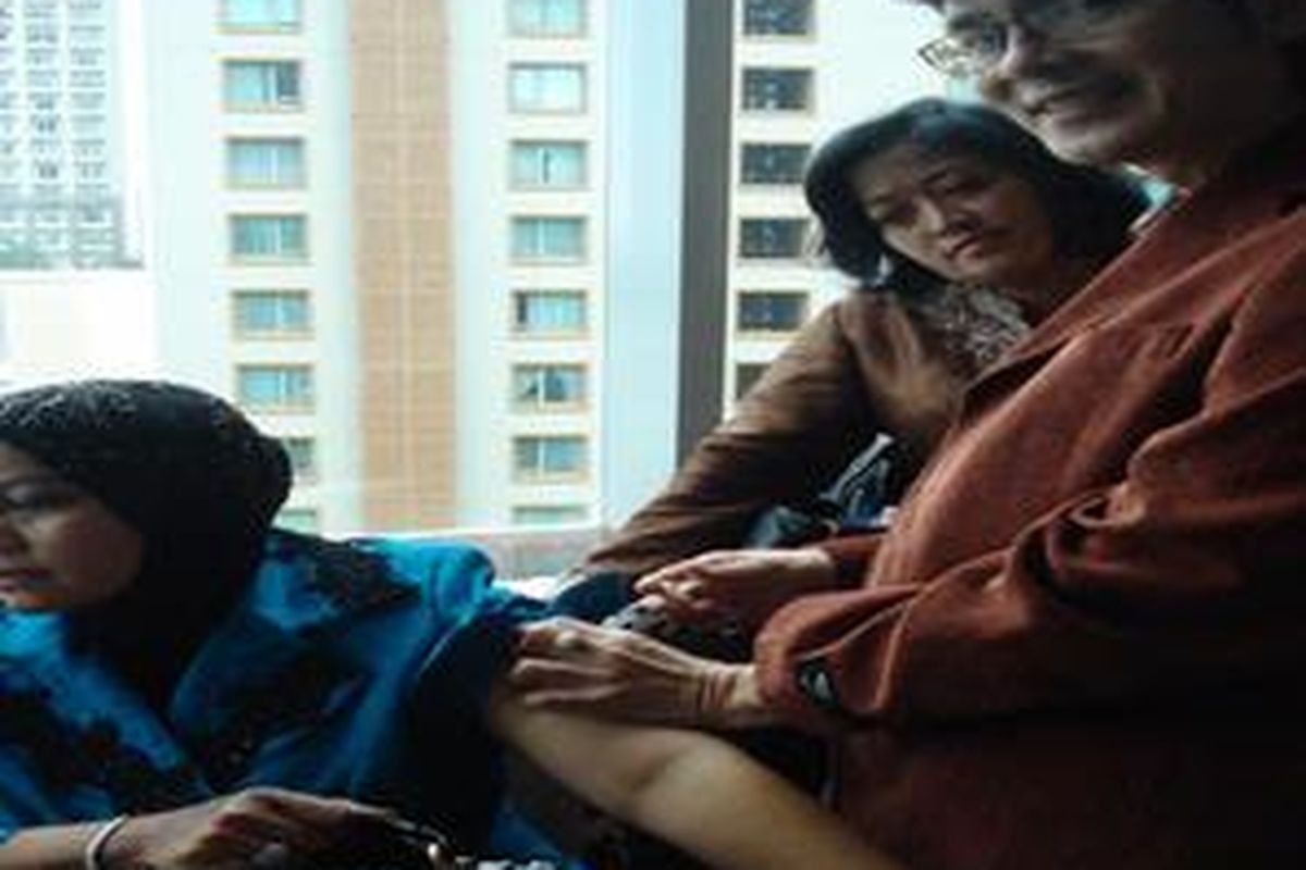 Dr. Boyke D. N. memberikan suntikan vaksinasi kanker serviks kepada seorang ibu di acara Beautiful Life yang berlangsung di Grand Kempinski Hotel Indonesia (25/2)