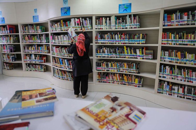 Pustakawan merapihkan tumpukan buku-buku di Perpustakaan Nasional di Jalan Medan Merdeka Selatan, Jakarta Pusat, Rabu (8/11/2017). Perpustakaan Nasional dengan total 24 lantai dan tiga ruang bawah tanah merupakan gedung perpustakaan tertinggi di dunia. KOMPAS.com/GARRY ANDREW LOTULUNG